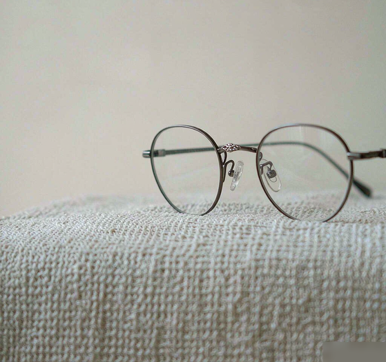 Delicate eyeglasses resting on a soft cloth