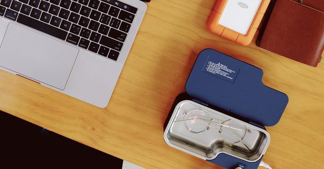 Blue GT SONIC ultrasonic glasses cleaner with eyeglasses on an office desk